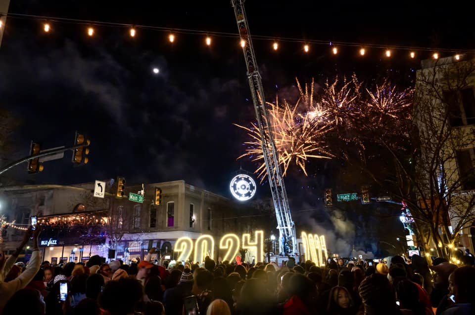 Crowd gathered on Front Street as the Hub Sign glows overhead.